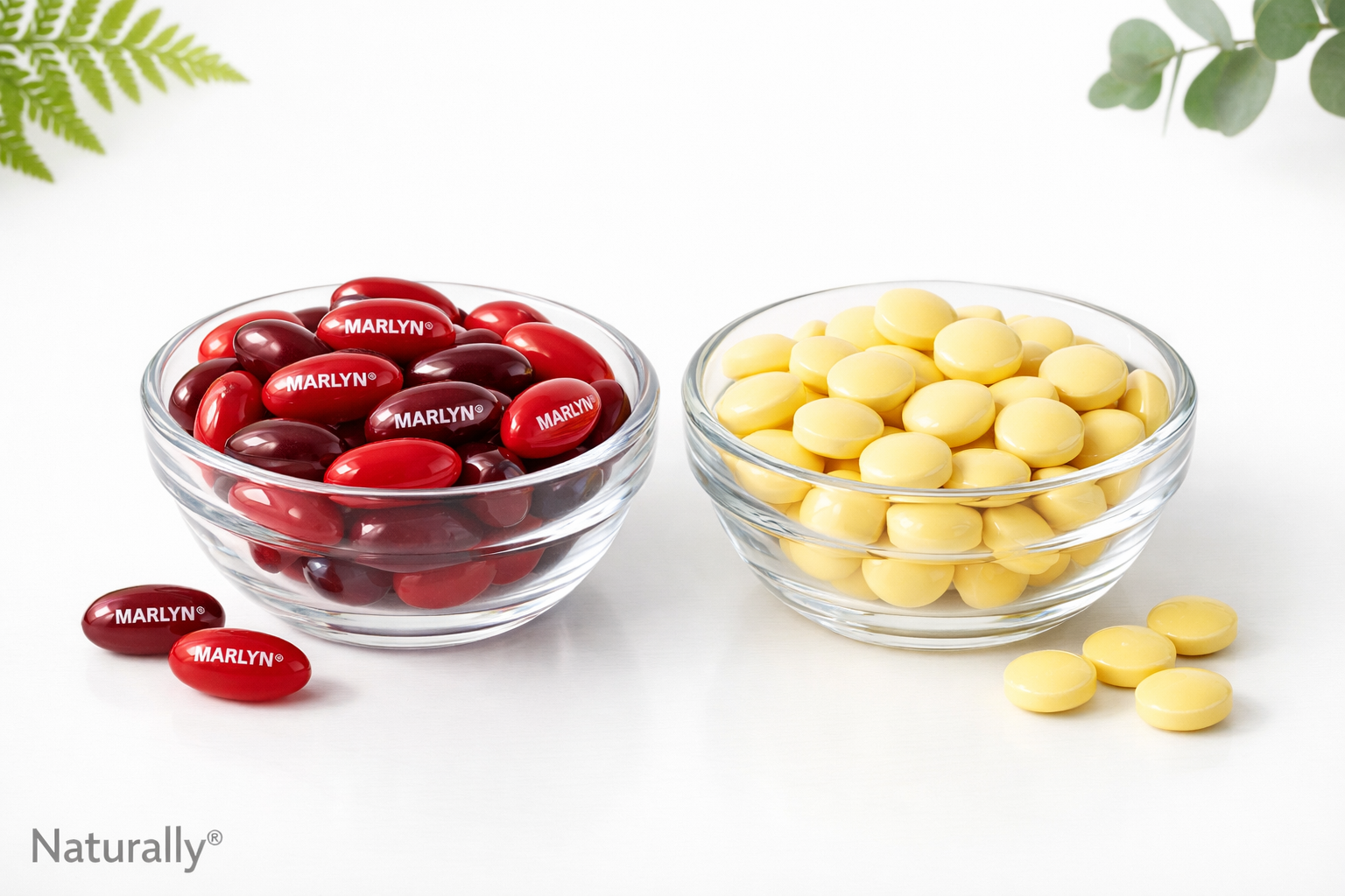 Two bowls containing sample softgels and tablets of Naturally® Vitamins products